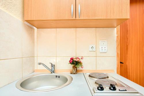 - un comptoir de cuisine avec un évier et un vase de fleurs dans l'établissement Apartments Porto Bjelila, à Tivat