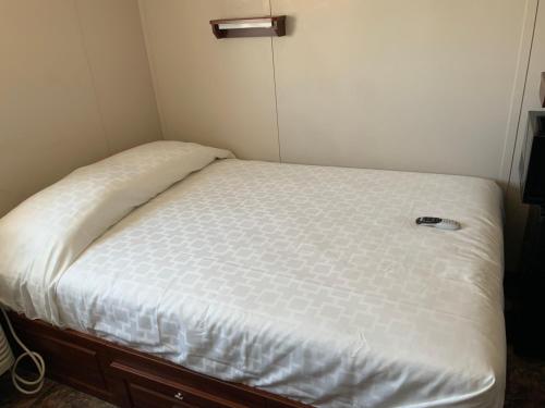 een bed in een kleine kamer met een wit matras bij Karbani Inn in Carlsbad