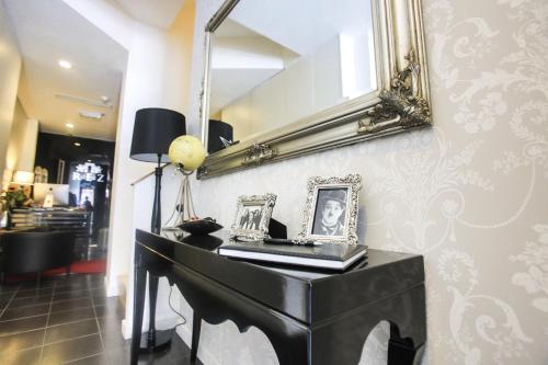 un espejo en una pared sobre un piano negro en Room Home Stay, en Londres