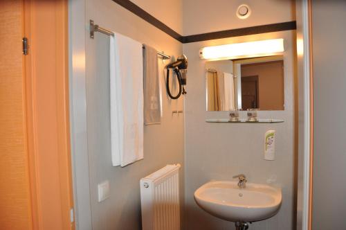 a bathroom with a sink and a mirror at MOTEL ARBOTEL 24h self check-in in Friesach