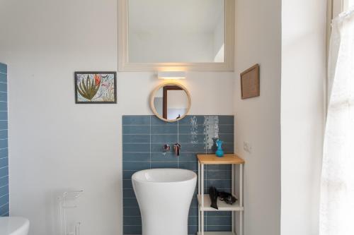 a bathroom with a white sink and blue tiles at AMERICA NEI BOSCHI B&B in Bra
