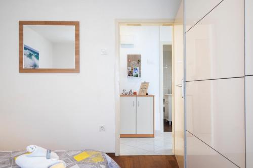 1 dormitorio con paredes blancas y armario de cristal en Castropola Apartment, en Pula