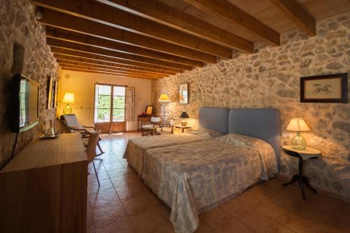a bedroom with a bed and a stone wall at Agroturismo Can Feliu in Porreres