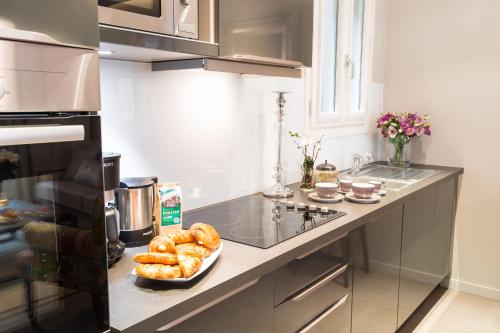 a kitchen with a plate of donuts on a counter at Hôtel Roi de Sicile - Rivoli in Paris
