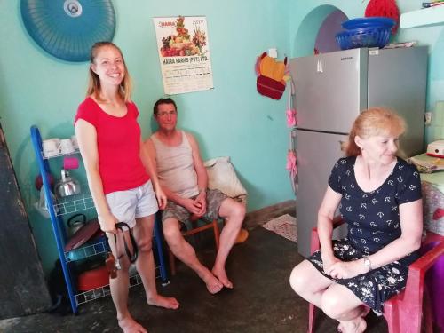 a group of three people sitting in a kitchen at Dreamscape home stay in Kandy