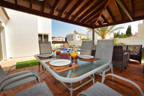 a table and chairs on a patio with a table at Villa Nissi Gold in Ayia Napa