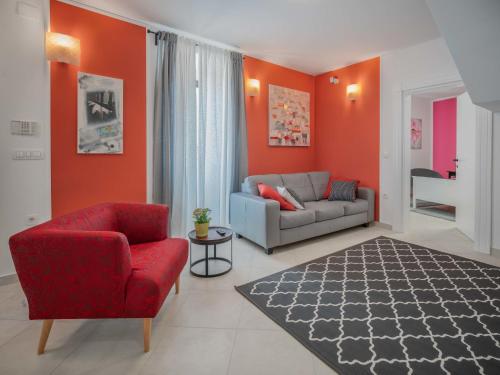 a living room with orange walls and a couch and chair at Holiday Home Amberg by Interhome in Kastav