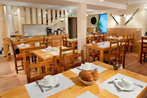 a dining room with wooden tables and chairs at Chalet Hotel La Tarine in Peisey-Nancroix