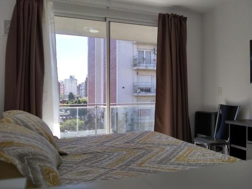um quarto com uma cama e uma grande janela em Pasco 1847 Apartamento 5B em Rosário