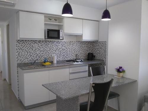 a kitchen with white cabinets and a counter top at Pasco 1847 Apartamento 5B in Rosario
