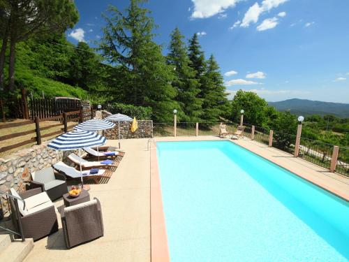 a swimming pool with lounge chairs and umbrellas next to at Holiday Home La Fornace by Interhome in Roccastrada