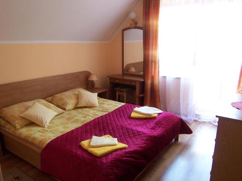 a bedroom with a bed with two towels on it at Holiday Home Mielno 2 by Interhome in Mielno