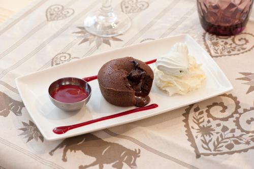 a plate with a chocolate cake and whipped cream at Chalet Hotel La Tarine in Peisey-Nancroix