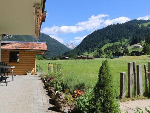 a patio with a view of a field and a house at Apartment Lärchehus by Interhome in Gstaad