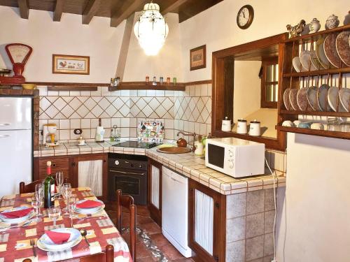cocina con mesa y microondas blanco en Holiday Home Camino La Candelaria-2 by Interhome, en La Orotava