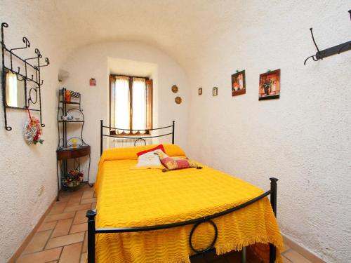 a bedroom with a bed with a yellow blanket at Holiday Home La Fornace by Interhome in Roccastrada