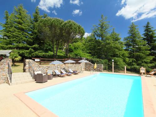 a swimming pool in a yard with chairs and trees at Holiday Home La Fornace by Interhome in Roccastrada