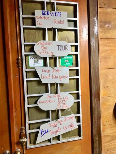 a door with a bunch of signs on it at Green Hill Hostel & Tour in Ha Giang