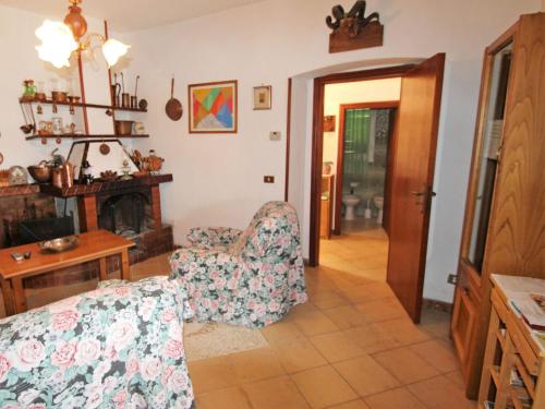 ein Wohnzimmer mit einem Stuhl und einem Kamin in der Unterkunft Apartment Cristina by Interhome in Bracco
