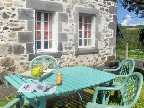 una mesa de picnic azul frente a una casa de piedra en Holiday Home O'Petit Bonheur by Interhome, en Langlerial