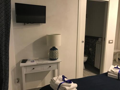 una camera da letto con TV e tavolo con lampada di B&B Casa Gaia a Città della Pieve