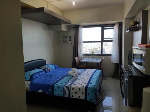 Cette petite chambre comprend 2 lits et une fenêtre. dans l'établissement KC Studio 4 at Horizon 101 Cebu, à Cebu