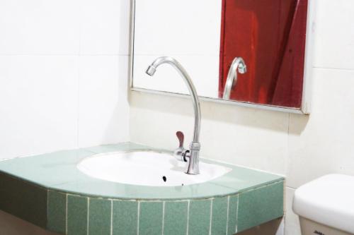 ein Bad mit einem Waschbecken und einem Spiegel in der Unterkunft Plaza Inn in Sibu