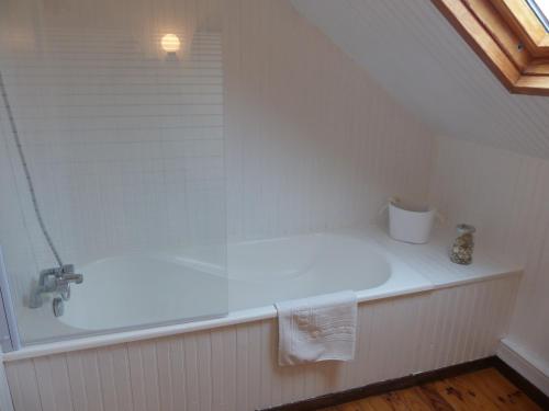 La salle de bains est pourvue d'une baignoire et d'un lavabo. dans l'établissement Le Domaine des Tostes, à Bonneville-la-Louvet
