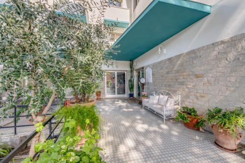 an outdoor patio with a couch and plants at Hotel Massimo in Marina di Cecina