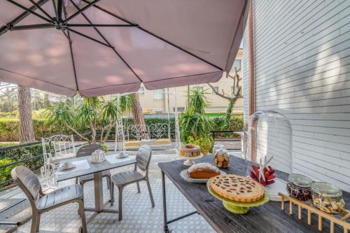 a patio with a table and chairs and an umbrella at Hotel Massimo in Marina di Cecina