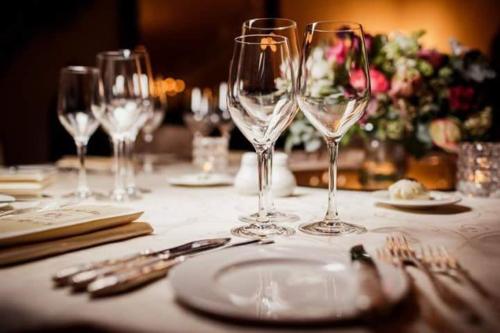 a table with wine glasses and a plate on it at Hotel La Algodonera in Ambato