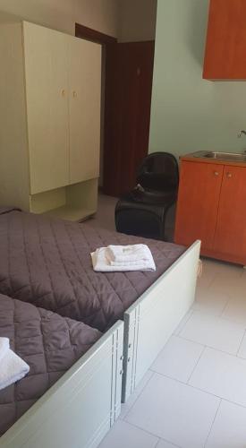 a room with a bed and a cabinet and a chair at Athina Apartments Tolo in Tolo
