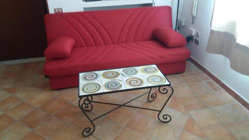 a red couch with a table in front of it at Casa Panorama Amalfi Coast in Vietri sul Mare