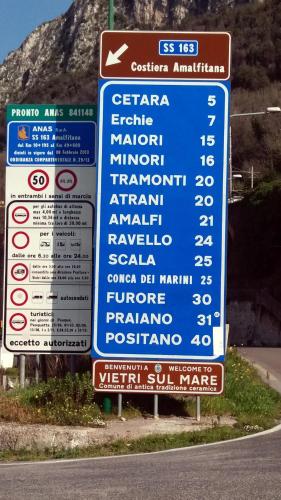 a sign with many different signs on the side of a road at Casa Panorama Amalfi Coast in Vietri sul Mare