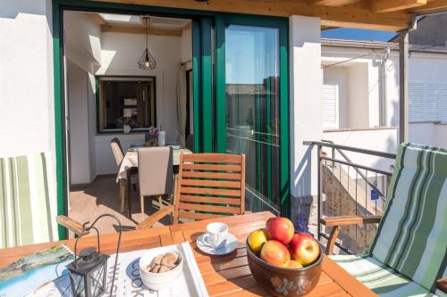 a table with a bowl of fruit on a balcony at Holiday Home Punat in Punat