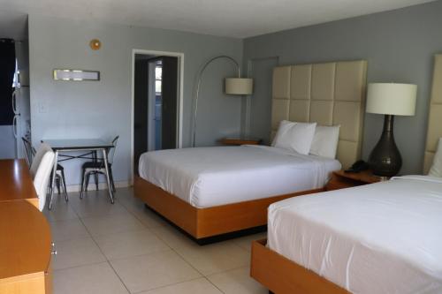 ein Hotelzimmer mit 2 Betten und einem Tisch in der Unterkunft Ocean Mile Hotel in Fort Lauderdale