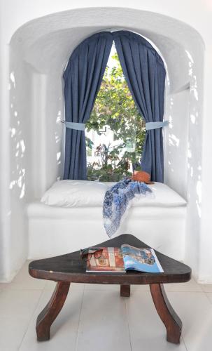 a table with an umbrella in front of a window at Villa Ravino Secret Retreat in Ischia