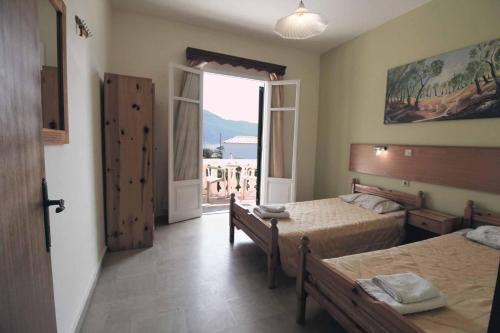 a bedroom with two beds and a large window at House Dimitri Agios Georgios Pagoi Corfu in Agios Georgios Pagon