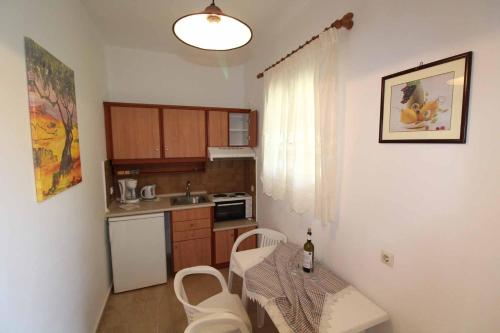 a small kitchen with a table and chairs in a room at House Dimitri Agios Georgios Pagoi Corfu in Agios Georgios Pagon