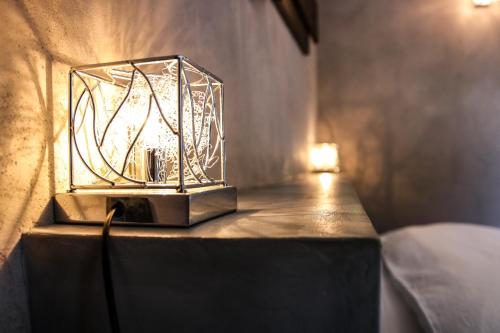 a glass lantern sitting on a table with a lamp at Le Mas de la Lombarde in Lourmarin