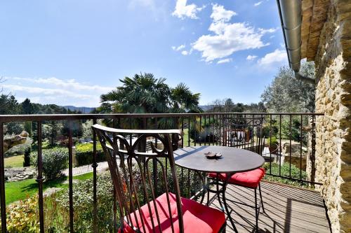 a patio with a table and chairs on a balcony at Le Mas de la Lombarde in Lourmarin