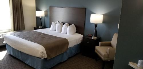 a hotel room with a bed and a chair at AmericInn by Wyndham Sioux Falls North in Sioux Falls