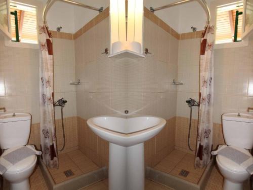 ein weißes Badezimmer mit 2 WCs und einem Waschbecken in der Unterkunft House Dimitri Agios Georgios Pagoi Corfu in Agios Georgios Pagon