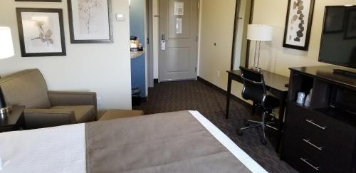 a hotel room with a bed and a television at AmericInn by Wyndham Sioux Falls North in Sioux Falls
