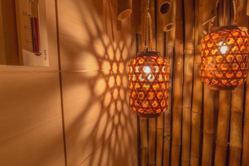 two orange lights hanging from a wall with a shadow at Windeby 7T in Wenningstedt