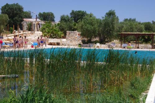 a pool at a resort with people standing around it at Masseria Sciaiani Piccola in Villa Castelli