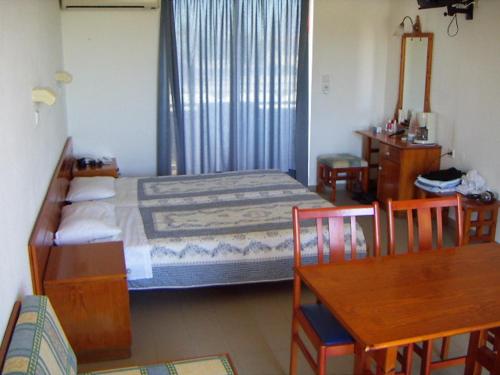 a bedroom with a bed and a table and chairs at Palmasol Hotel in Triánta