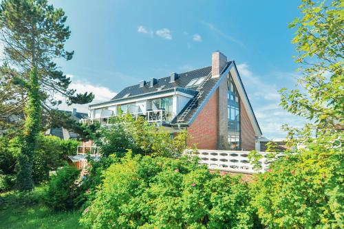 a large house on a hill with trees at Windeby 7T in Wenningstedt