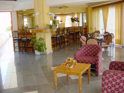 a lobby with chairs and a table and a bar at Palmasol Hotel in Triánta
