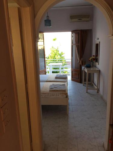 a bedroom with a bed and a room with a window at Hebes on the beach in Kavos